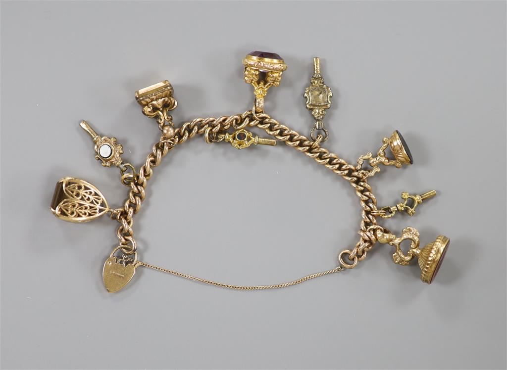 A 9ct. charm bracelet hung with nine assorted gold and gold plated seals, watch keys, etc. gross 66.3 grams.